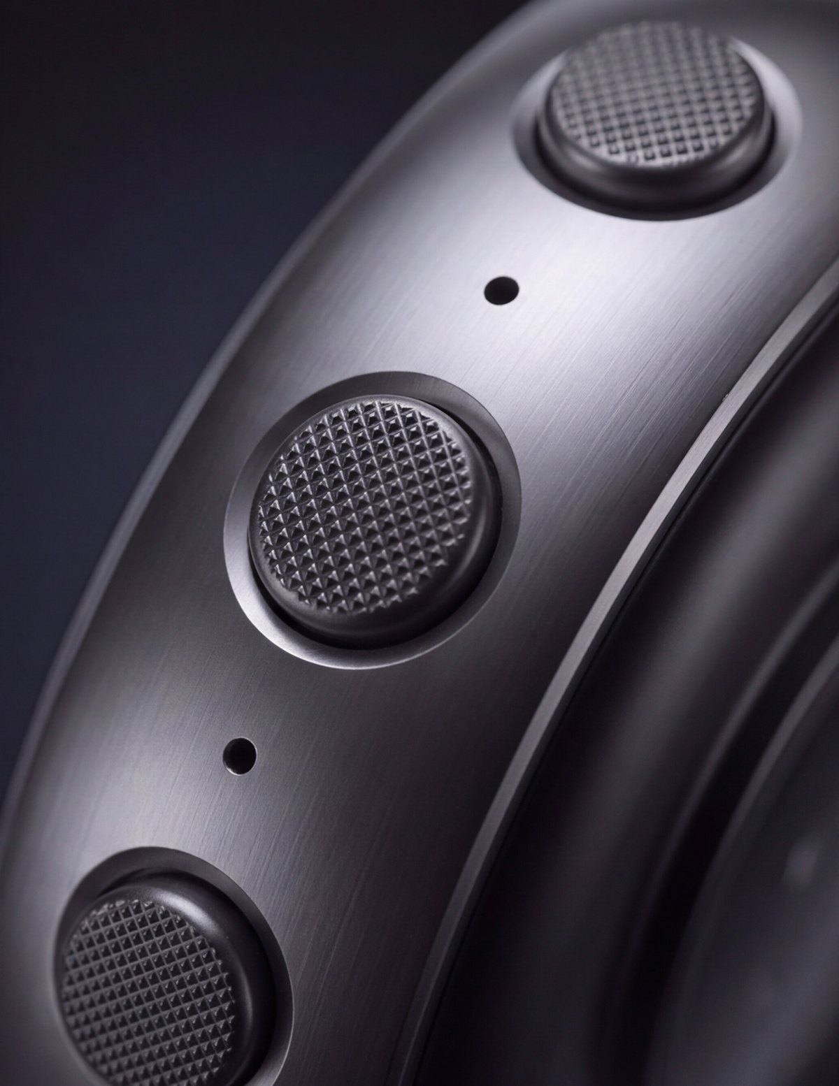 Side profile of the brushed steel case and its three knurled controls.
